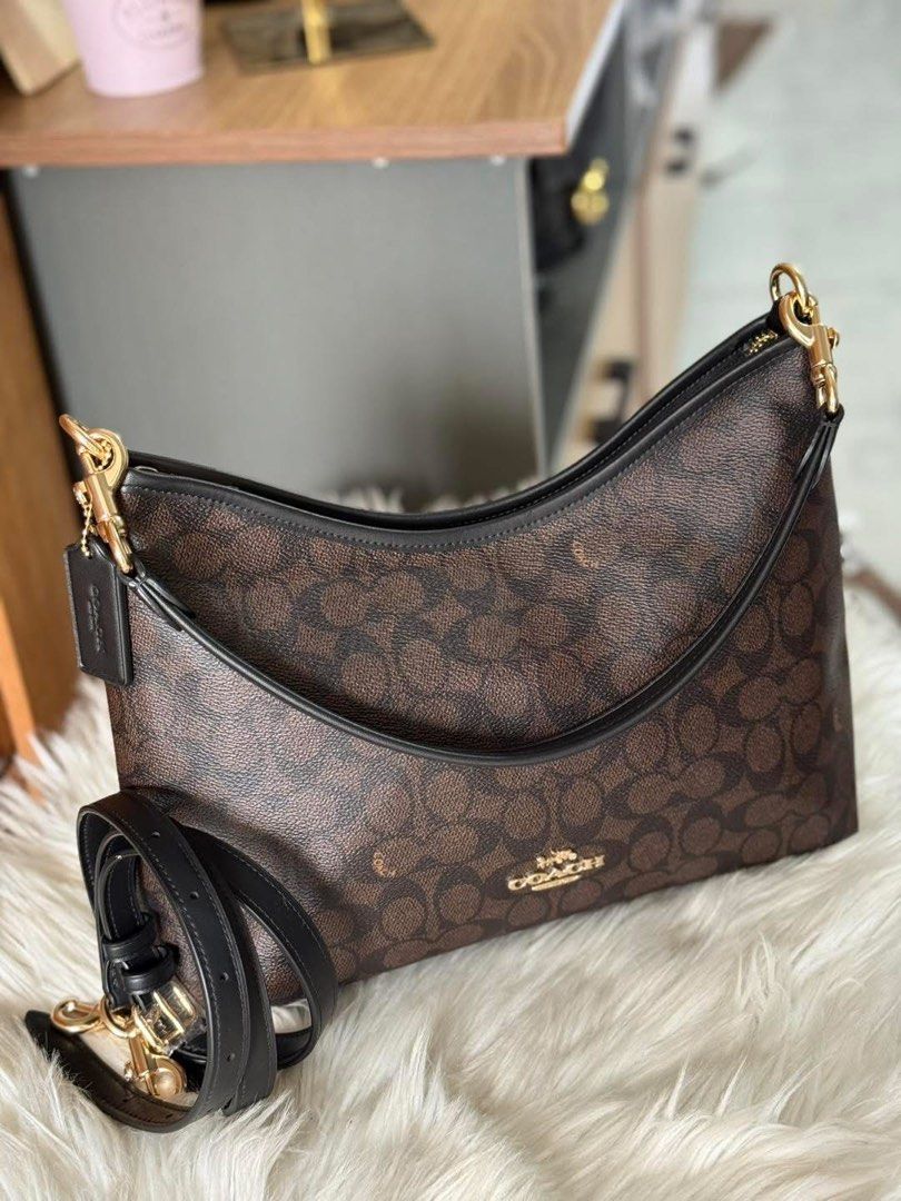 Coach Signature Shoulder Bag (Category: Shoulder Bags) located in Manila. Submitted by clairetot (Listing ID 1431337361, Image 1). Description: Coach shoulder bag in signature brown print. Features black leather strap, gold hardware, and detachable strap. Classic design with zippered closure..