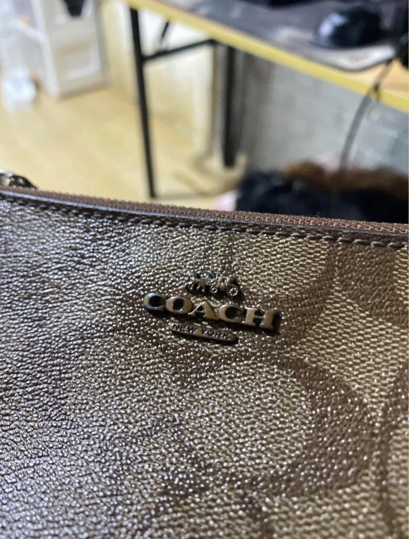 Coach Signature Wristlet (Category: Luxury Bags & Wallets) located in Manila. Submitted by declutterwithpeanut (Listing ID 1431323323, Image 2). Description: - Authentic Coach wristlet - Signature brown Coach pattern - Zip closure - Wrist strap - Dual compartment design - Features Coach logo.