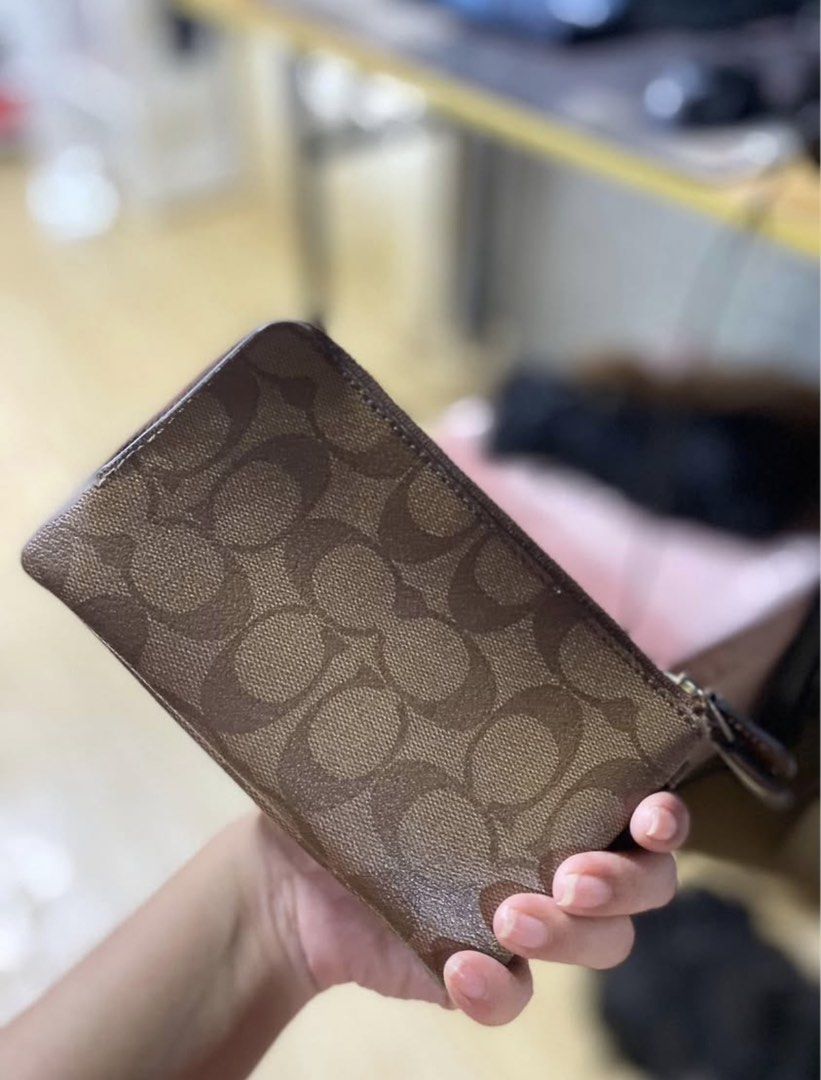 Coach Signature Wristlet (Category: Luxury Bags & Wallets) located in Manila. Submitted by declutterwithpeanut (Listing ID 1431323323, Image 3). Description: - Authentic Coach wristlet - Signature brown Coach pattern - Zip closure - Wrist strap - Dual compartment design - Features Coach logo.