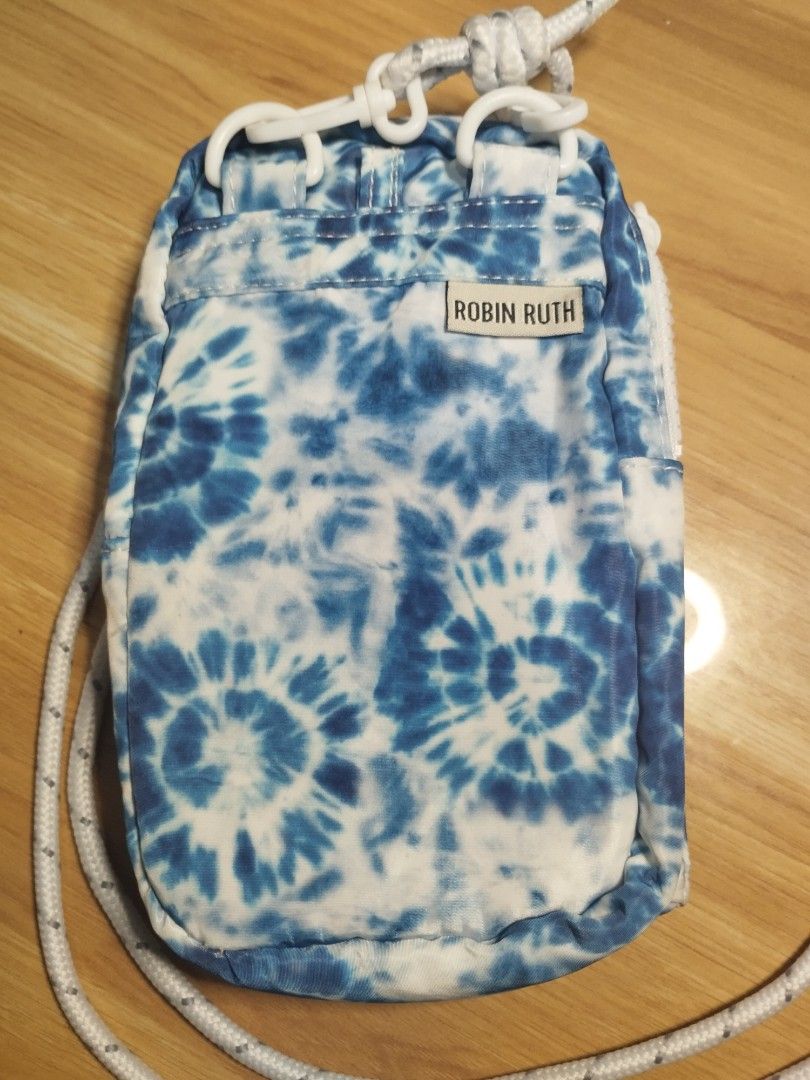 Robin Ruth New York Crossbody Bag (Category: Cross-body Bags) located in Carmona. Submitted by ichorvault (Listing ID 1431328296, Image 2). Description: - Brand: Robin Ruth - Design: Blue tie-dye pattern - Features: - Front pocket with velcro closure - Main compartment with zipper - White rope strap - Label: "New York".