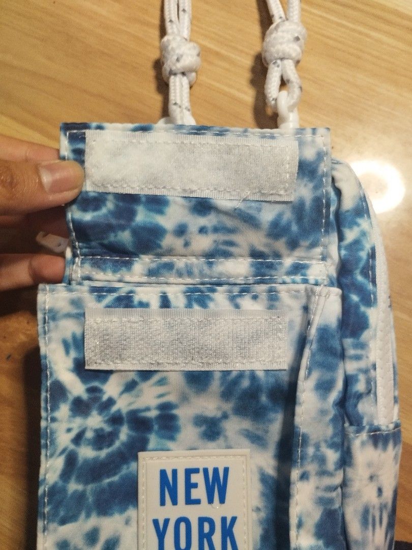 Robin Ruth New York Crossbody Bag (Category: Cross-body Bags) located in Carmona. Submitted by ichorvault (Listing ID 1431328296, Image 3). Description: - Brand: Robin Ruth - Design: Blue tie-dye pattern - Features: - Front pocket with velcro closure - Main compartment with zipper - White rope strap - Label: "New York".