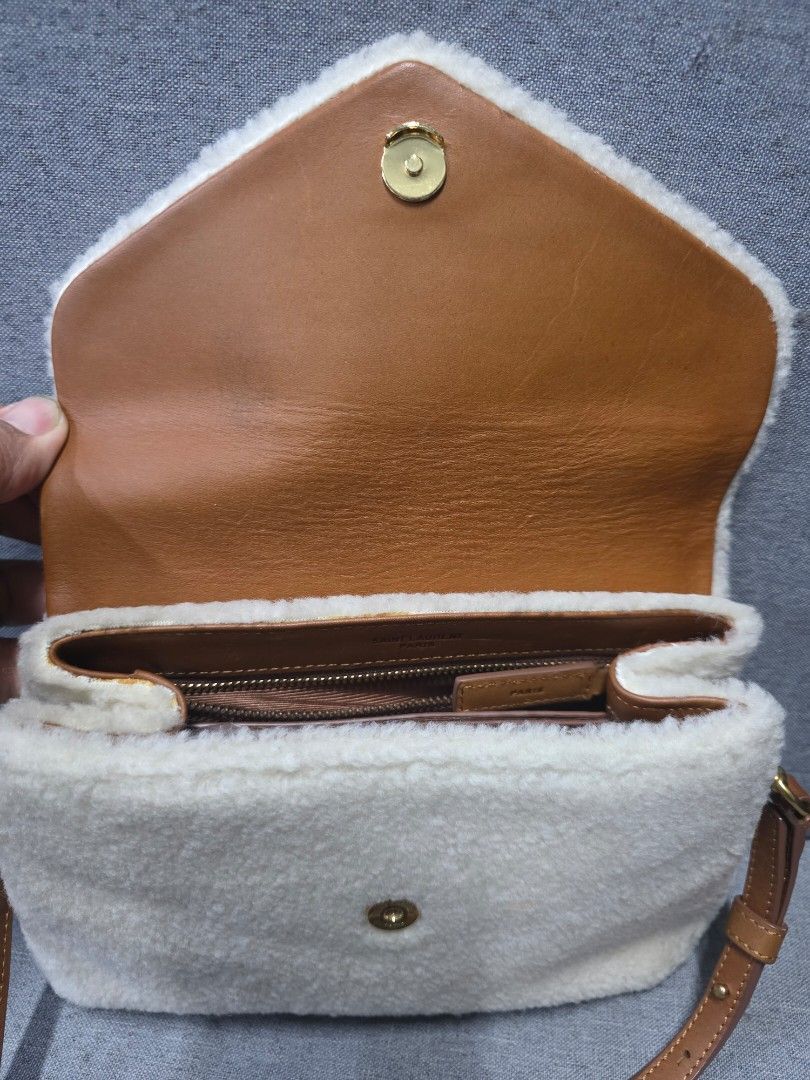 Saint Laurent Shearling Shoulder Bag (Category: Luxury Bags & Wallets) located in General Trias. Submitted by roselle2230 (Listing ID 1431300974, Image 2). Description: - Saint Laurent shoulder bag - Shearling exterior - Leather strap - Gold-toned hardware - Magnetic snap closure - Interior zippered pocket - Interior card slots - Saint Laurent Paris logo inside.