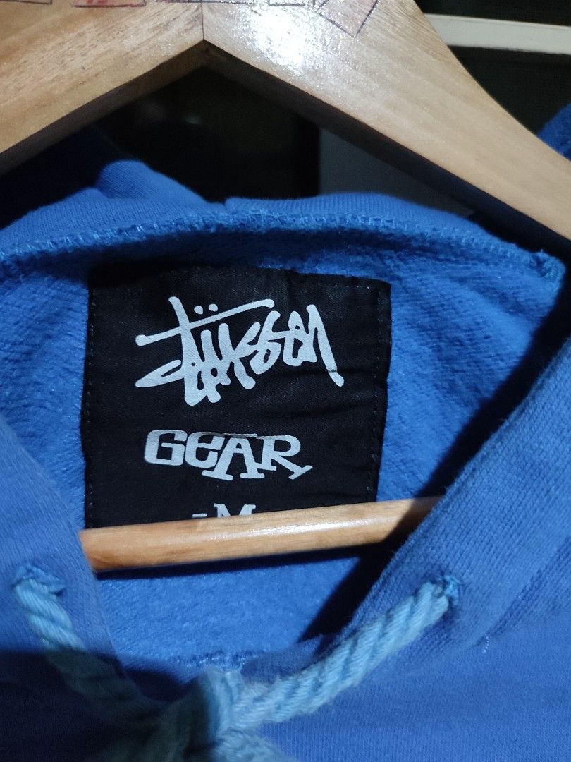 Stussy Gear Hoodie (Category: Hoodies) located in Antipolo. Submitted by thriftedjames (Listing ID 1431332353, Image 3). Description: - Stussy Gear hoodie - Color: Blue - Size: M - Design: Front logo and skull graphic on the back - Features: Drawstring hood and kangaroo pocket - Material: Comfortable - Style: Casual and versatile.
