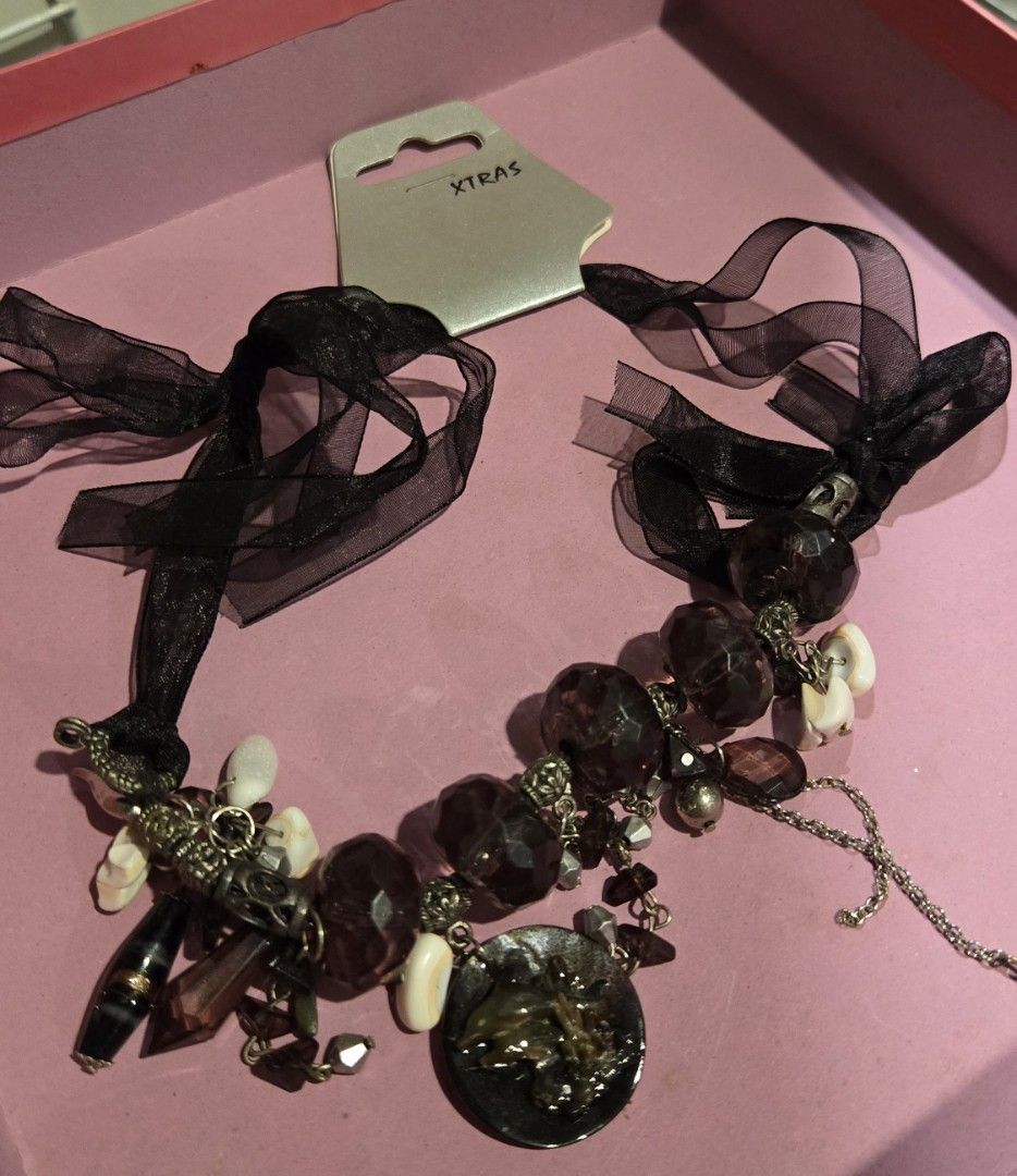 XTEAS Beaded Necklace with Ribbon (Category: Necklaces) located in Mandaue City. Submitted by janchc (Listing ID 1431312536, Image 1). Description: - New necklace - Unique design with dark purple beads and white accents - Includes a decorative pendant - Black ribbon ties for closure - Comes with original tag - Perfect accessory to elevate any outfit.