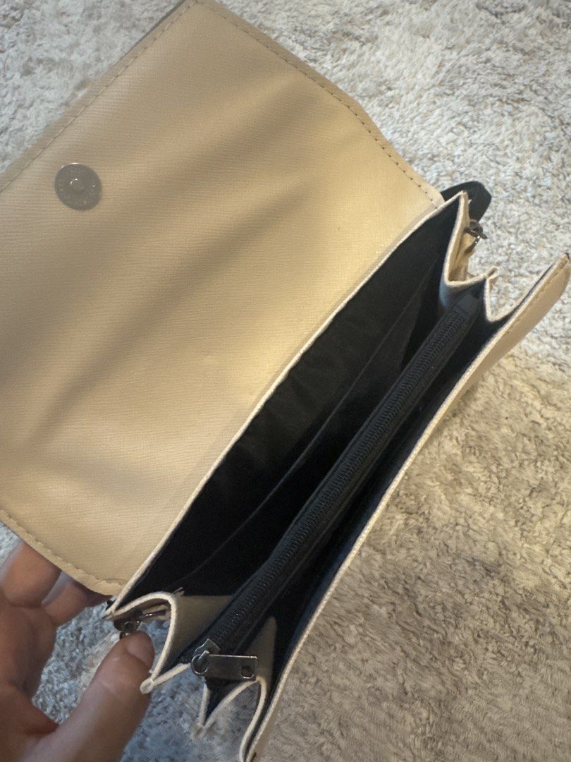 Yohji Yamamoto Y's Crossbody Wallet Bag - Black and Beige (Category: Cross-body Bags) located in Singapore. Submitted by greatworldand (Listing ID 1431223917, Image 2). Description: - Stylish Y's crossbody wallet bag - Classic black and beige color - Multiple compartments for cards and cash - Zippered pocket for security - Includes a long strap - Perfect for everyday use.