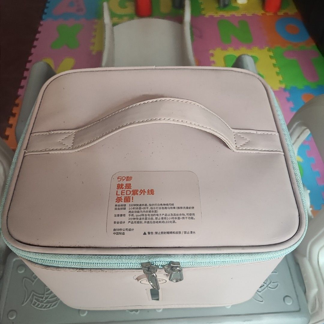 59S LED UV Sterilizer Box (Category: Breastfeeding & Bottle Feeding) located in Mandaluyong City. Submitted by karisse628 (Listing ID 1431429935, Image 2). Description: - 59S LED UV sterilizer box - Easy to carry with a handle - Secure zipper closure - Includes a rack and small accessory - Comes with a power cord - Stylish pink design with a light blue zipper.