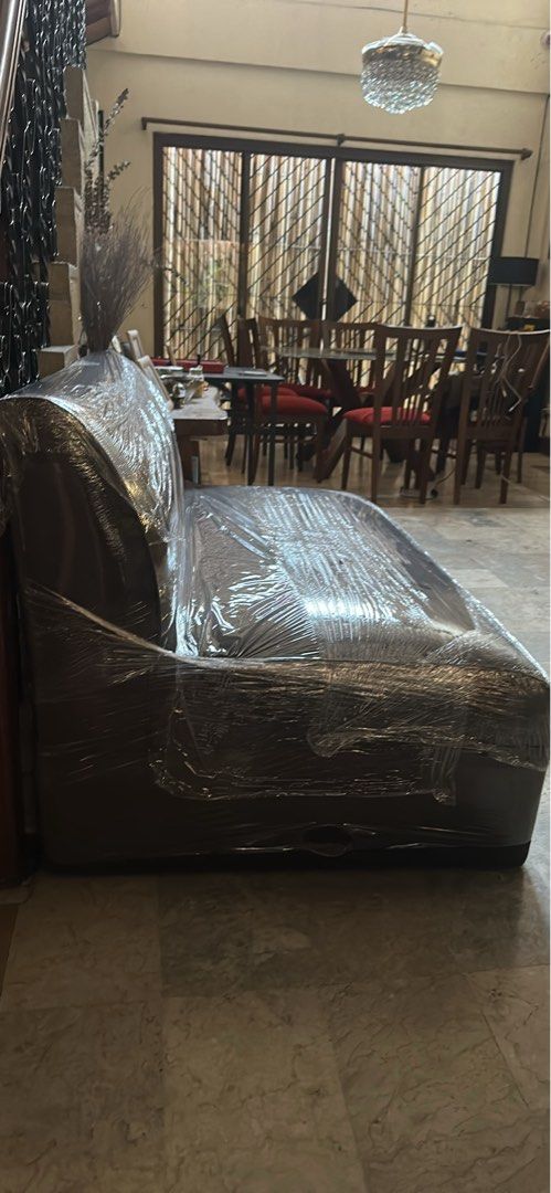 Brown Chaise Lounge Sofa (Category: Sofas) located in Muntinlupa City. Submitted by alyssagill (Listing ID 1431468259, Image 1). Description: - Brown chaise lounge sofa, wrapped in plastic. - Features a curved back and long seat. - Includes a separate brown sofa..