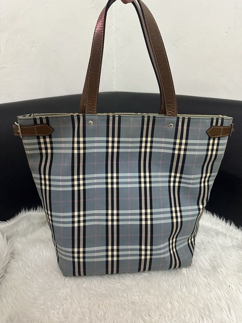 Burberry Blue Label Tote Bag (Category: Luxury Bags & Wallets) located in Marilao. Submitted by curleylux (Listing ID 1431413246, Image 1). Description: - Burberry Blue Label tote bag - Classic check pattern - Brown leather handles and trim - Interior zip pocket - Spacious interior - Exterior wear on corners - Magnetic snap closure.