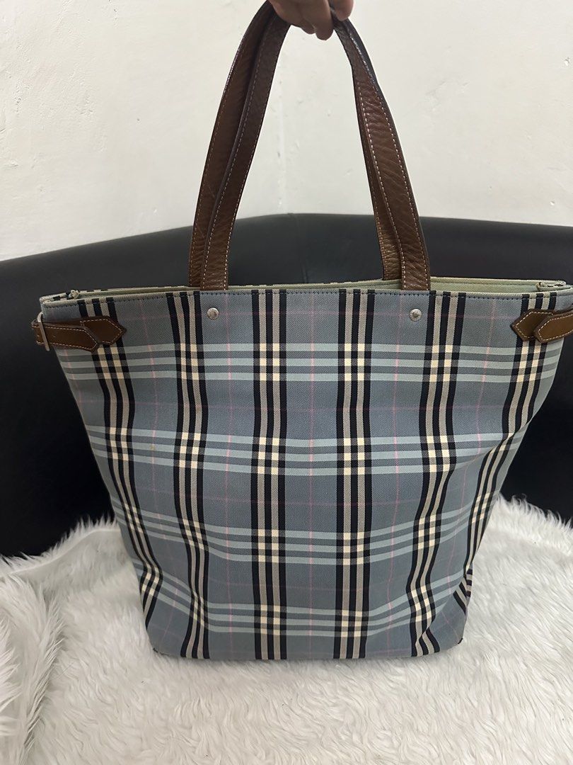 Burberry Blue Label Tote Bag (Category: Luxury Bags & Wallets) located in Marilao. Submitted by curleylux (Listing ID 1431413246, Image 2). Description: - Burberry Blue Label tote bag - Classic check pattern - Brown leather handles and trim - Interior zip pocket - Spacious interior - Exterior wear on corners - Magnetic snap closure.