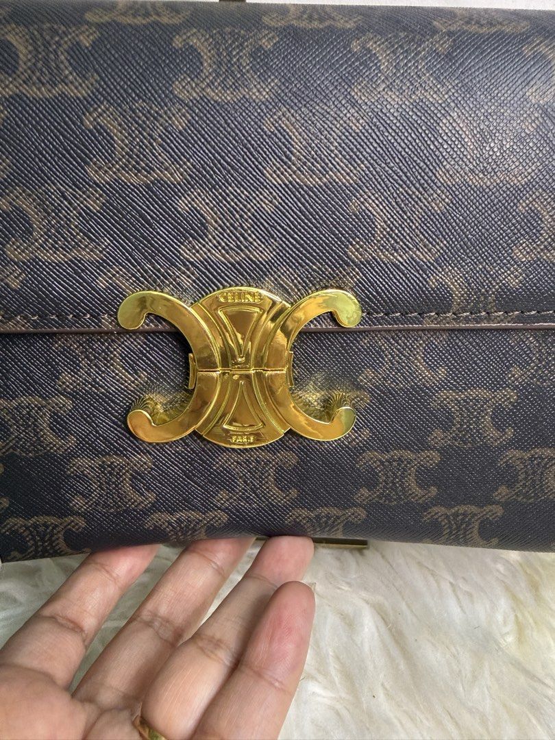 Celine Triomphe Shoulder Bag (Category: Luxury Bags & Wallets) located in Consolacion. Submitted by naome1. (Listing ID 1431482672, Image 2). Description: - Celine Triomphe shoulder bag - Iconic Triomphe clasp - Brown monogram pattern - Brown leather strap - Gold-tone hardware - Brown leather interior - Celine Paris logo - Serial number: SP2175.