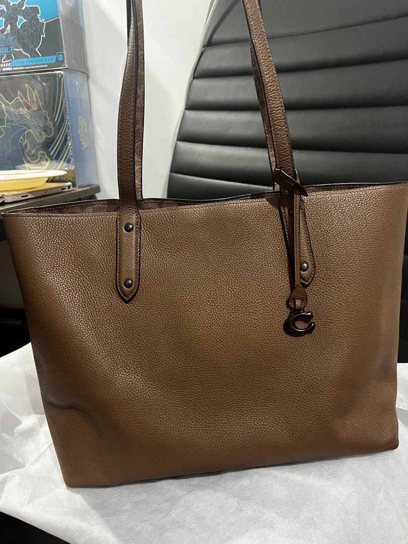 Coach Central Tote Bag (Category: Luxury Bags & Wallets) located in Quezon City. Submitted by ellastore (Listing ID 1422663737, Image 1). Description: Minor signs of use only Minimal rubs sa corner Still in 8/10 condition Missing hang tag Fits laptop - Coach tote bag - Brown exterior, patterned interior - Made of leather - Features double handles - Includes a Coach charm - Spacious design - Interior zippered pocket - Ideal for everyday use.