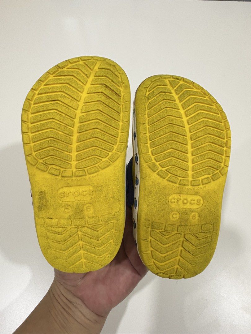 Crocs Minions Clog Shoes Size C6 (Category: Babies & Kids Fashion) located in Manila. Submitted by analyntorr16083 (Listing ID 1431480642, Image 3). Description: - Yellow Crocs clogs with Minions design - Size: C6 - Features a blue strap and white border - Multiple ventilation holes - Authentic Crocs logo on sole.
