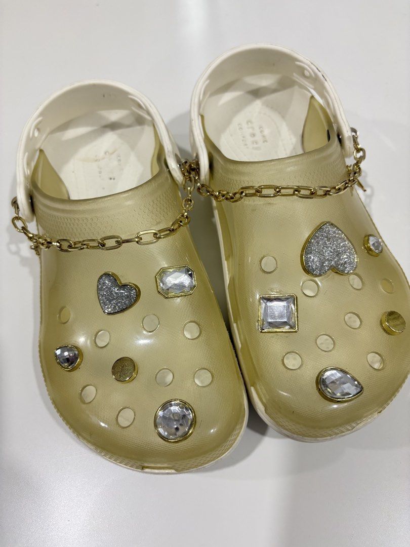 Crocs Sandals with Chain and Embellishments c7 (Category: Flats & Sandals) located in Manila. Submitted by analyntorr16083 (Listing ID 1431481414, Image 2). Description: - Transparent upper and white base Crocs sandals - Features decorative chains, rhinestones, and heart accents - Comfortable design, ideal for casual use - Some wear on soles.