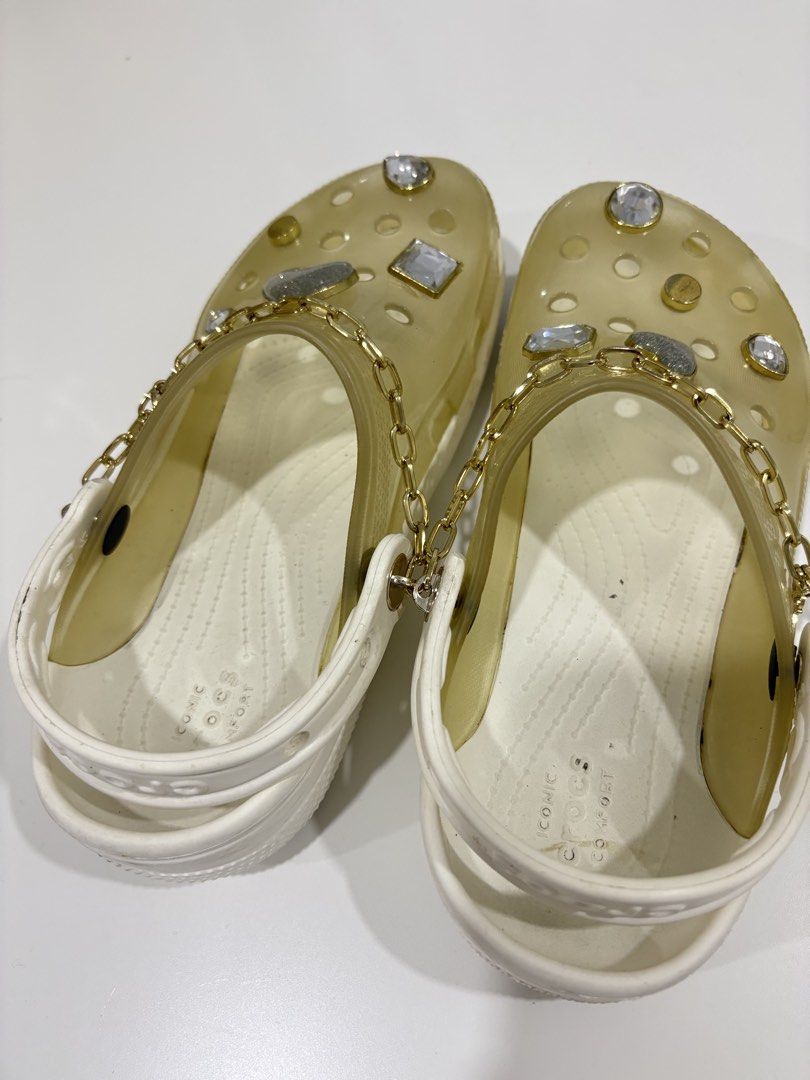Crocs Sandals with Chain and Embellishments c7 (Category: Flats & Sandals) located in Manila. Submitted by analyntorr16083 (Listing ID 1431481414, Image 1). Description: - Transparent upper and white base Crocs sandals - Features decorative chains, rhinestones, and heart accents - Comfortable design, ideal for casual use - Some wear on soles.