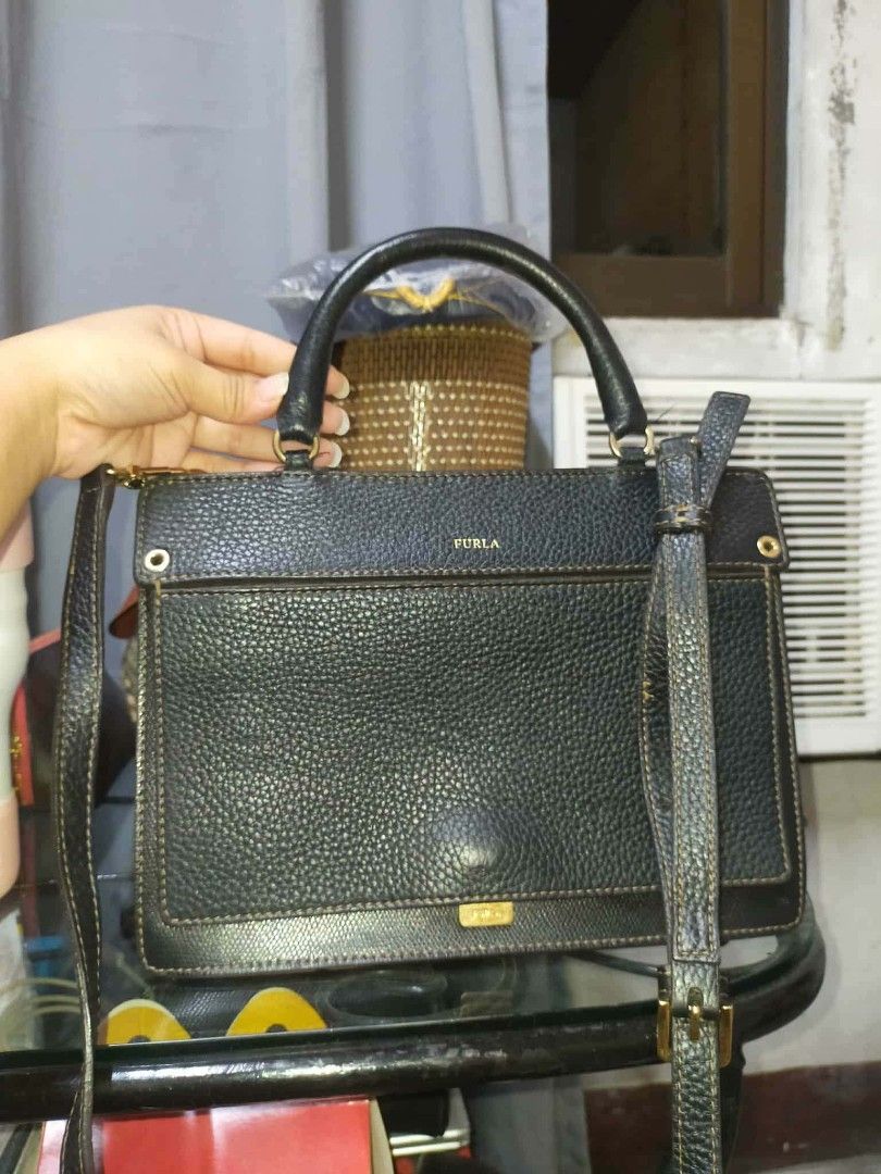 Furla Black Leather Handbag (Category: Luxury Bags & Wallets) located in Manila. Submitted by cvntyy (Listing ID 1431436745, Image 1). Description: - Authentic Furla handbag - Black color - Top handle and detachable shoulder strap - Rectangular shape - Textured leather exterior - Gold-tone hardware - Flap closure - Spacious interior - Versatile design helping a friend!! .