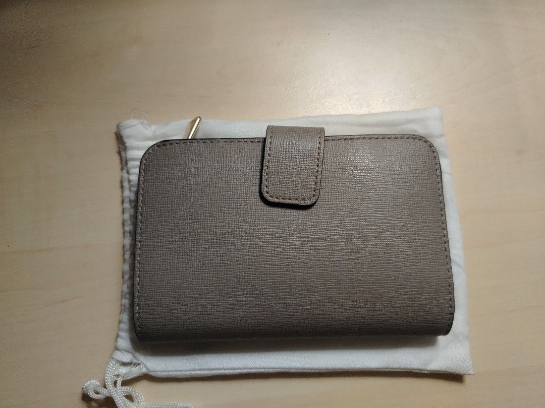 Furla Compact Wallet (Category: Luxury Bags & Wallets) located in Caloocan City. Submitted by jpygoodies (Listing ID 1431558155, Image 2). Description: - Furla wallet in a neutral taupe color - Compact and easy to carry - Features both zip-around and snap closures for security - Includes original dust bag - Genuine Furla logo visible - Crafted from textured leather.