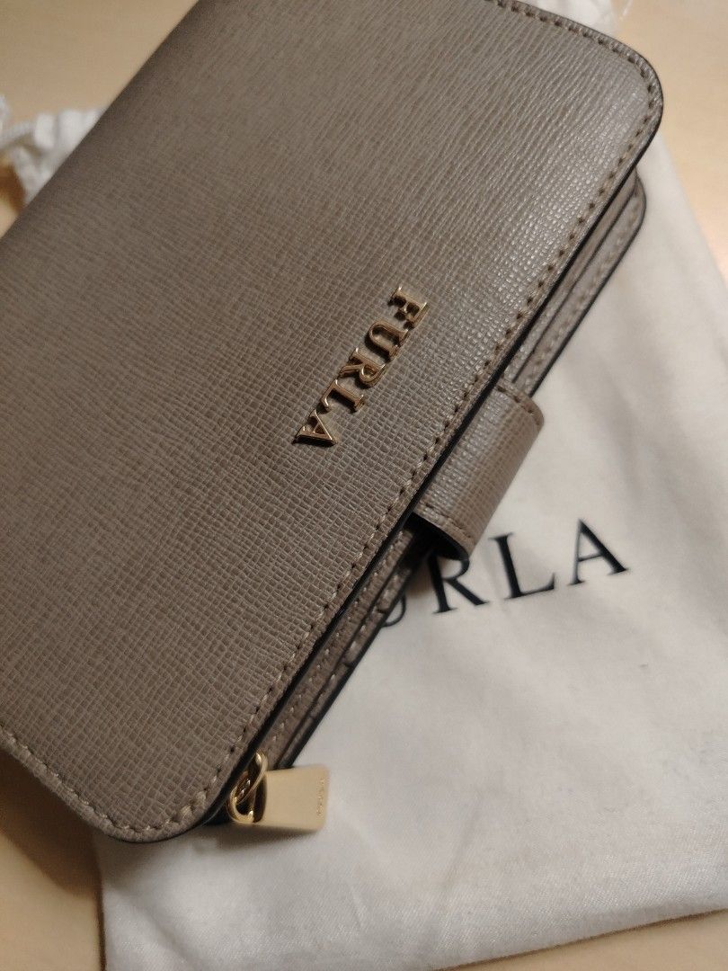 Furla Compact Wallet (Category: Luxury Bags & Wallets) located in Caloocan City. Submitted by jpygoodies (Listing ID 1431558155, Image 3). Description: - Furla wallet in a neutral taupe color - Compact and easy to carry - Features both zip-around and snap closures for security - Includes original dust bag - Genuine Furla logo visible - Crafted from textured leather.