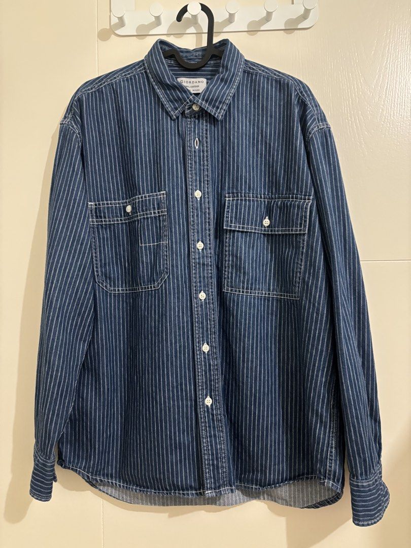 Giordano Striped Denim Shirt (Category: Formal Shirts) located in Pasig City. Submitted by kathB (Listing ID 1431539105, Image 1). Description: Giordano men’s denim shirt (size M) in a relaxed fit, featuring vertical white stripes, contrast stitching, and unique double chest pockets. Made from 100% cotton with a button-down front. Oversized on petites since it’s men’s sizing. I usually wear a women’s XL and this fits just right. Measurement (L x 