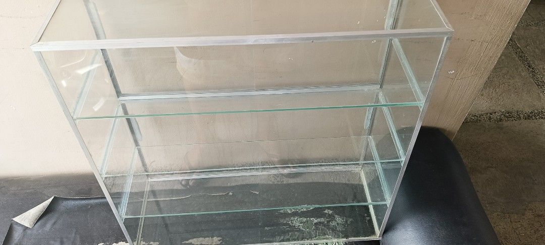 Glass Display Cabinet with Shelves (Category: Shelves, Cabinets & Racks) located in Bacoor. Submitted by icemanice02 (Listing ID 1431511276, Image 2). Description: - Rectangular glass display cabinet - Sturdy metal frame - Clear glass panels for optimal visibility - Multiple glass shelves - Ideal for showcasing collectibles, merchandise, or decorative items - Clean and modern aesthetic.