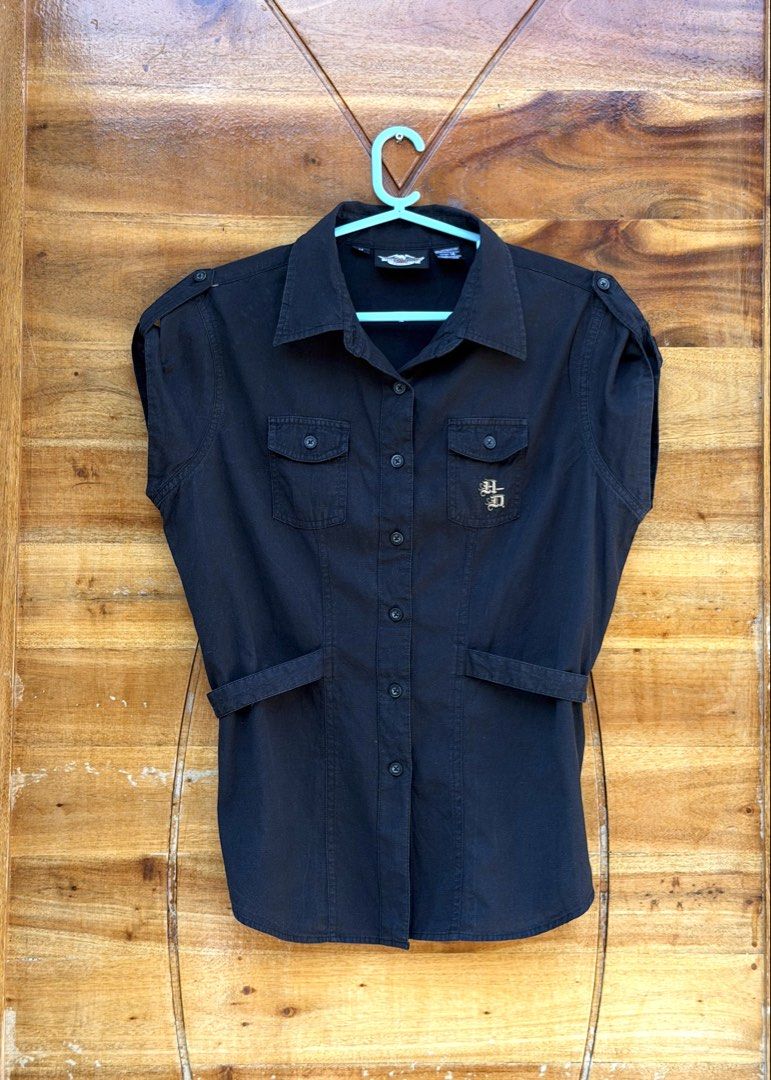 Harley-Davidson Black Short Sleeve Shirt (Category: Blouses) located in Cavite. Submitted by peppermintsss (Listing ID 1431440889, Image 2). Description: - Harley-Davidson black short sleeve shirt - Size: Medium - Features: - Button-down front - Two chest pockets - Tie detail at waist - Embroidered Harley-Davidson logo (front and back) - Material: Cotton ‼️bust: 38” ‼️Length: 24.5” 🛵 SF will be shouldered by the buyer.
