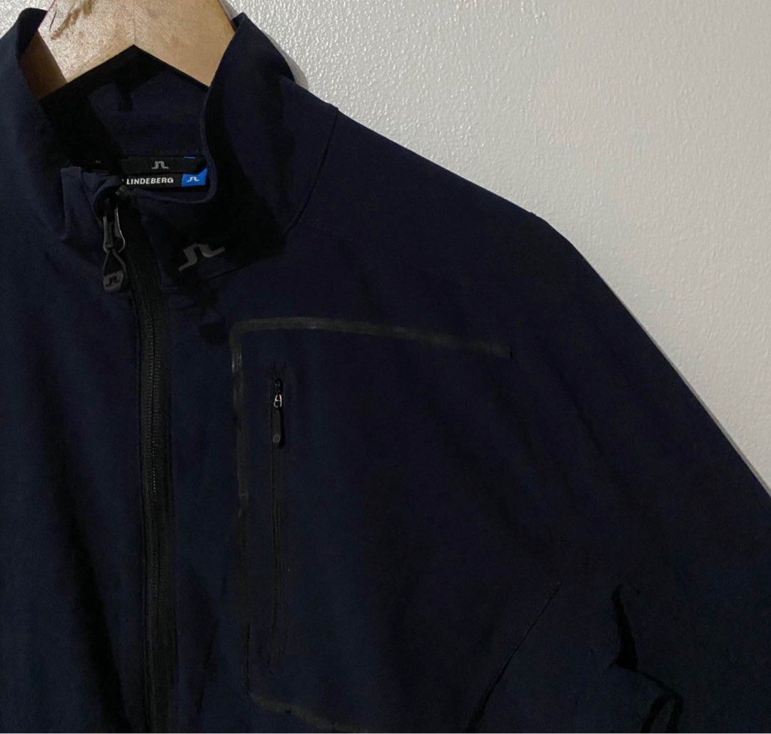 J. Lindeberg Navy Jacket (Category: Coats, Jackets and Outerwear) located in Manila. Submitted by takemystuffbuymystuff (Listing ID 1431422822, Image 2). Description: - J. Lindeberg navy blue jacket - Full zip closure - Multiple zip pockets - J. Lindeberg logo on back and collar - Stand-up collar - Made of polyester and elastane blend - Made in Vietnam.