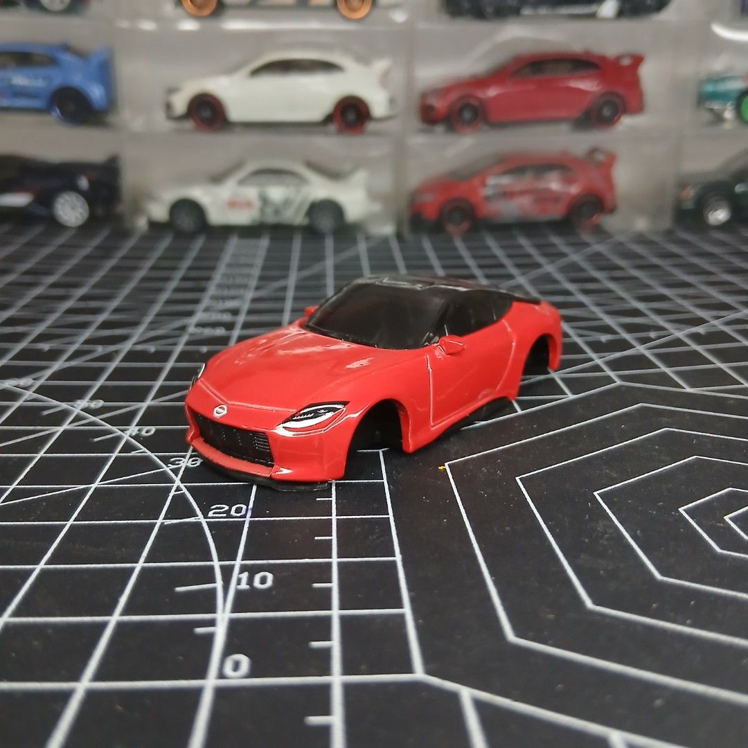 Nissan 400z Hot Wheels (Category: Vehicle & Diecast Models) located in Tanauan. Submitted by jeuskingz (Listing ID 1431534136, Image 1). Description: - MINT CONDITION - NO WHEELS - Red toy car - Black windows - Sleek design - Miniature model - Black surface with white lines .