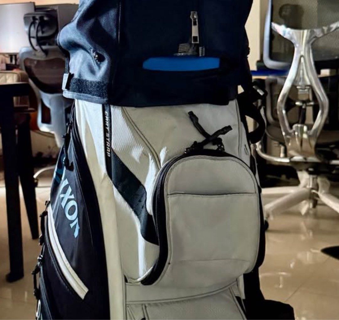 Srixon Golf Bag Sta. Elena Release (Category: Golf) located in Manila. Submitted by takemystuffbuymystuff (Listing ID 1431428365, Image 2). Description: - Srixon golf bag - Color scheme: Light grey, black, and blue accents - Multiple compartments for clubs - Several zippered pockets for accessories - Comfortable handle .