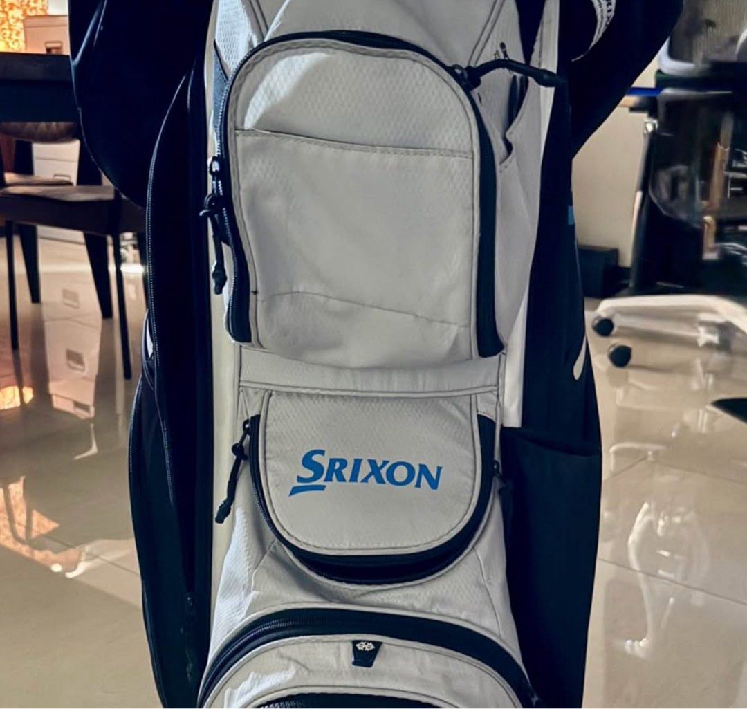 Srixon Golf Bag Sta. Elena Release (Category: Golf) located in Manila. Submitted by takemystuffbuymystuff (Listing ID 1431428365, Image 3). Description: - Srixon golf bag - Color scheme: Light grey, black, and blue accents - Multiple compartments for clubs - Several zippered pockets for accessories - Comfortable handle .