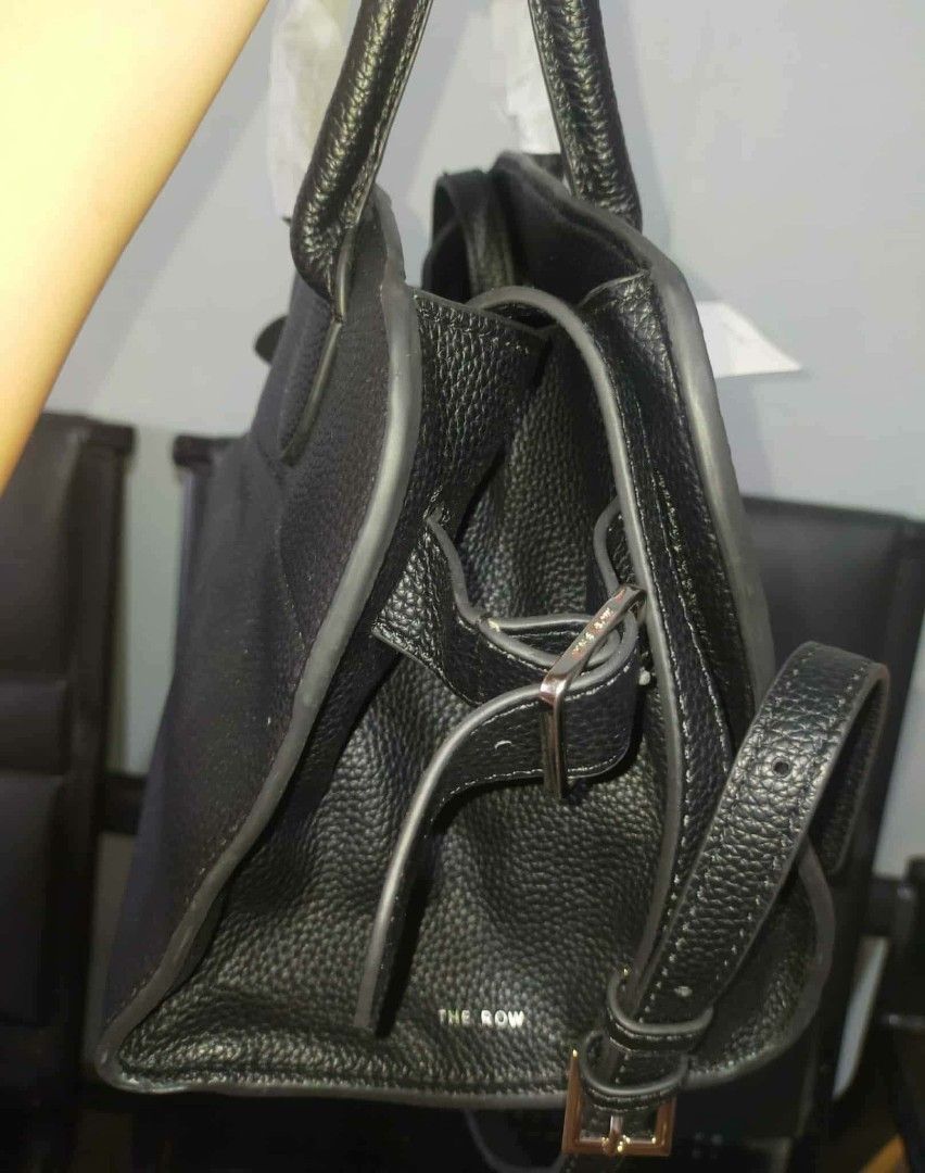 The Row Black Leather Handbag (Category: Luxury Bags & Wallets) located in Manila. Submitted by cvntyy (Listing ID 1431436806, Image 3). Description: - The Row black leather handbag - Top handle and detachable shoulder strap - Interior pocket - Textured leather exterior - Protective metal feet - Includes original tags helping a friend!! .