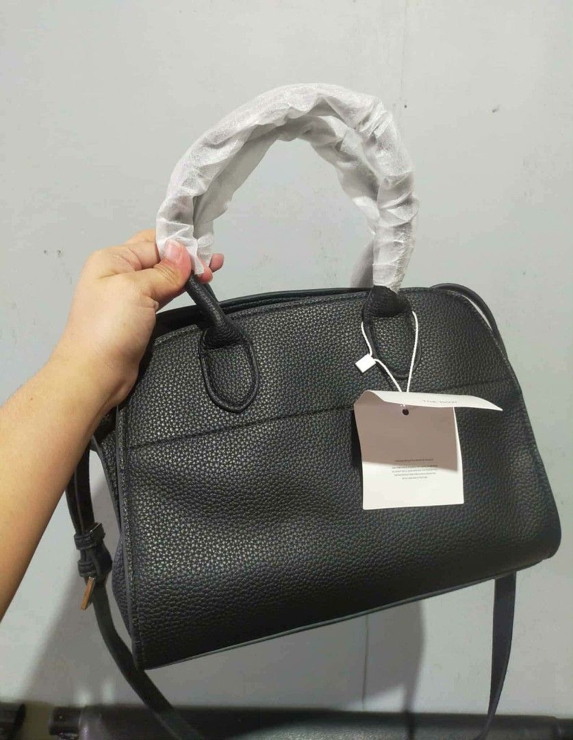 The Row Black Leather Handbag (Category: Luxury Bags & Wallets) located in Manila. Submitted by cvntyy (Listing ID 1431436806, Image 1). Description: - The Row black leather handbag - Top handle and detachable shoulder strap - Interior pocket - Textured leather exterior - Protective metal feet - Includes original tags helping a friend!! .
