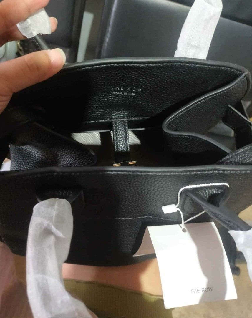 The Row Black Leather Handbag (Category: Luxury Bags & Wallets) located in Manila. Submitted by cvntyy (Listing ID 1431436806, Image 2). Description: - The Row black leather handbag - Top handle and detachable shoulder strap - Interior pocket - Textured leather exterior - Protective metal feet - Includes original tags helping a friend!! .