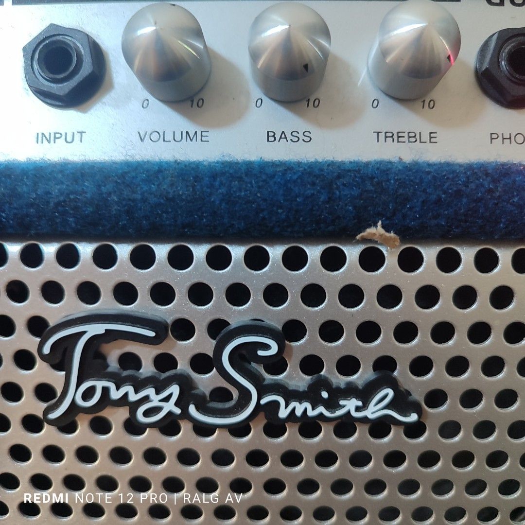 Tony Smith TG-75 Guitar Amplifier (Category: Musical Instruments) located in Bulacan. Submitted by ronald277077025 (Listing ID 1431468212, Image 3). Description: - Tony Smith TG-75 guitar amplifier - Controls: Input, Volume, Bass, Treble, Phone - Power switch and indicator light - Stylish blue fabric exterior - Metal speaker grill with Tony Smith logo - Includes caution label and power specifications on the back -110 volts.