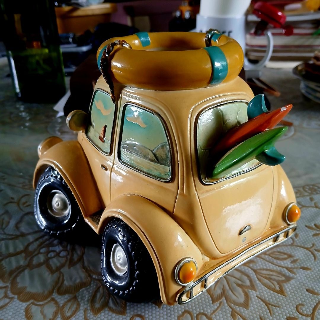 Vintage VW Beetle Figurine with Surfboards (Category: Vehicle & Diecast Models) located in Pasig City. Submitted by arlafontam89410 (Listing ID 1431395690, Image 2). Description: Surfy Yellow Volkswagen Beetle Model w/Surfboard & Lifebuoy Beach Theme This is a collectible ceramic collectible perfect for Volkswagen Beetles or beach enthusiasts. This classic vehicle features a well-loved yellow VW Bug and is adorned with surfing-themed accessories 