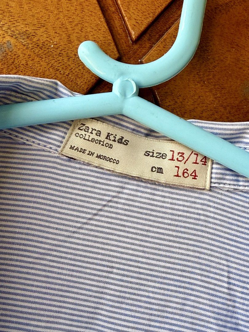 Zara Kids Striped Long Sleeves (Category: Babies & Kids Fashion) located in Cavite. Submitted by peppermintsss (Listing ID 1431435307, Image 3). Description: - Zara Kids striped shirt - Features a chest pocket - Classic collar and button-down closure - Color: Blue and white stripes with yellow side stripes - Size: 13/14 (164cm) - Made in Morocco ‼️Bust: 20” ‼️ Length: 24” 🛵 SF will be shouldered by the buyer.