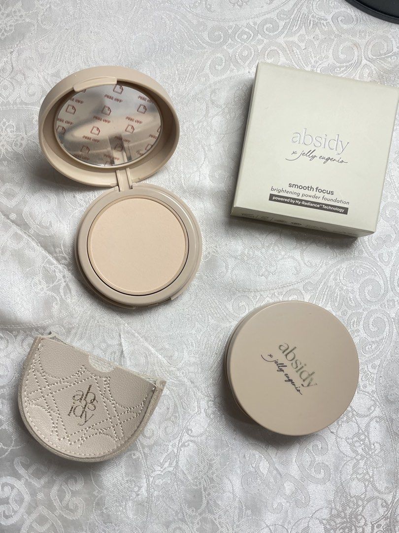 Absidy x Jelly Eugenio Smooth Focus Powder Foundation (Category: Makeup) located in Abucay. Submitted by declutterwyana (Listing ID 1431665574, Image 2). Description: - Absidy x Jelly Eugenio Smooth Focus Brightening Powder Foundation - Includes original box, compact, and puff - Available Shades: - 15 Fair Fresh - 25L1 Light-Medium Neutral - 9g of product - Compact features a mirror and protective film - Includes a protective case.
