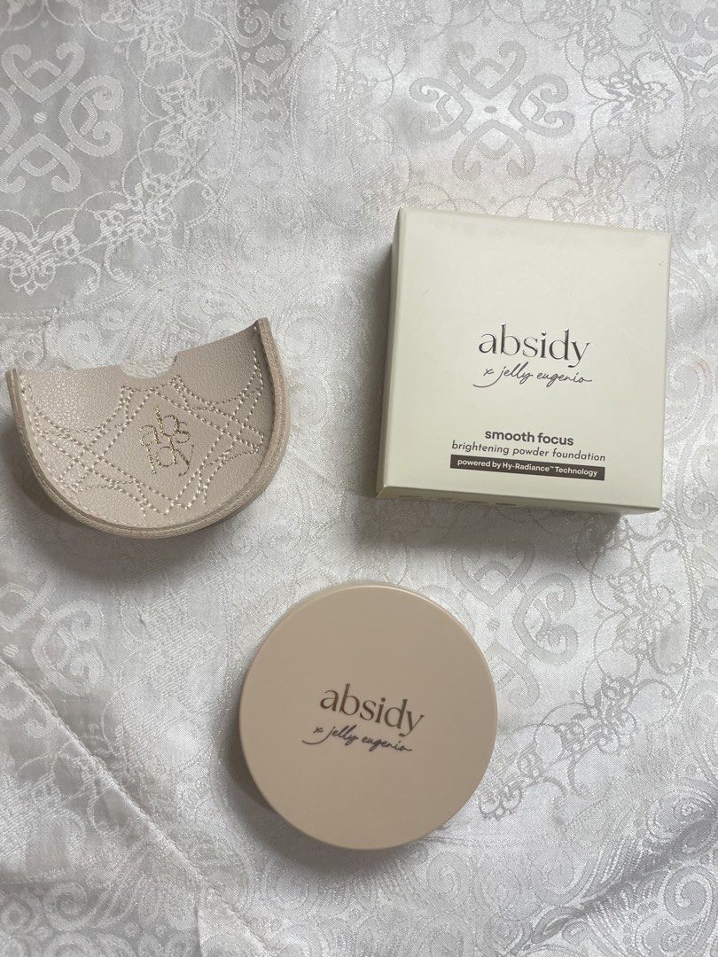 Absidy x Jelly Eugenio Smooth Focus Powder Foundation (Category: Makeup) located in Abucay. Submitted by declutterwyana (Listing ID 1431665574, Image 1). Description: - Absidy x Jelly Eugenio Smooth Focus Brightening Powder Foundation - Includes original box, compact, and puff - Available Shades: - 15 Fair Fresh - 25L1 Light-Medium Neutral - 9g of product - Compact features a mirror and protective film - Includes a protective case.