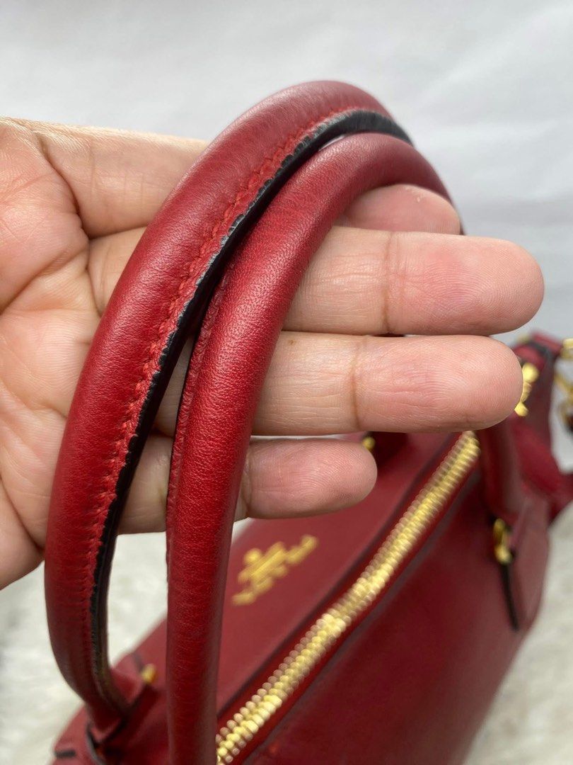 Authentic Prada Vitello Phenix 2-Way Bag (Category: Luxury Bags & Wallets) located in Quezon City. Submitted by arleeeneb (Listing ID 1431592574, Image 2). Description: Material: Grained Calfskin Leather (Vitello Phenix) • Hardware: Polished Gold-tone • Color: Red / Rosso • Condition: 9/10. Hardware is still bright, leather is supple with very minimal signs of wear. • Inclusions: Comes with detachable/adjustable shoulder strap and name tag..