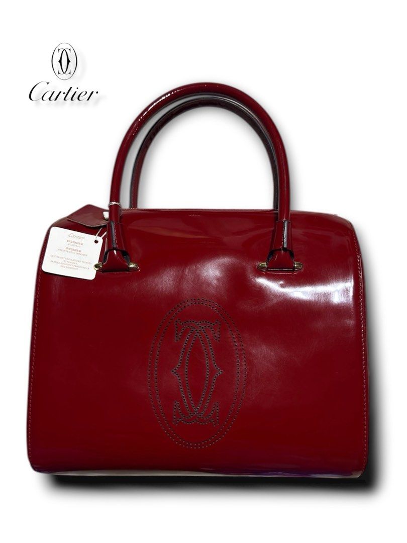 Cartier Red Patent Leather Handbag (Category: Luxury Bags & Wallets) located in Cebu City. Submitted by gabgaaab (Listing ID 1431613549, Image 2). Description: Cartier Marcello de Cartier Patent Leather Bowling Bag - Excellent Condition - Patent Calfskin Leather (Exterior); Knapp Finished Leather (Interior) - Color: Bordeaux / Ruby Red - Hardware: Gold-finish hardware with signature Double C logo zipper pulls - Interior: Neutral textile lining wi