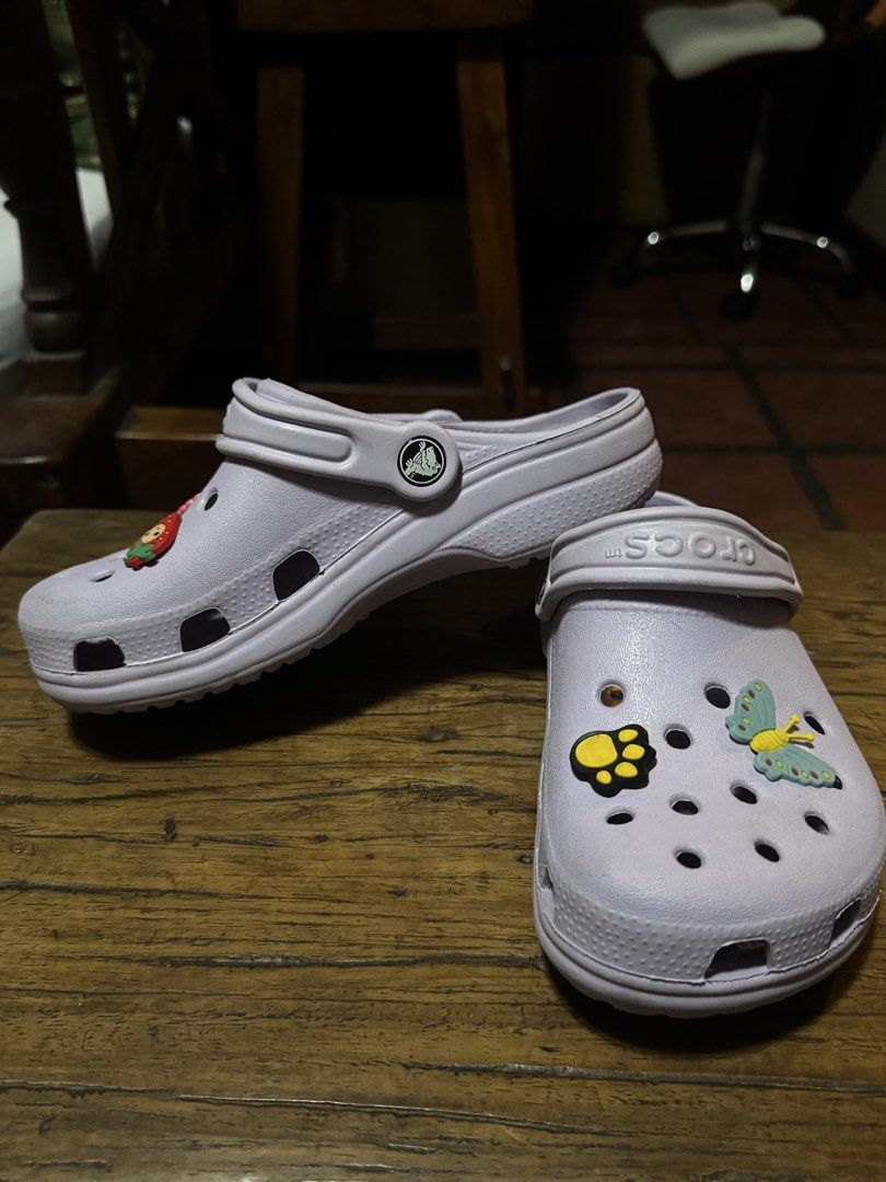 Crocs Lavender Clogs with Jibbitz - Size M3/W5 (Category: Slippers and slides) located in Quezon City. Submitted by limebasil (Listing ID 1431739605, Image 2). Description: - Lavender Crocs clogs - Includes butterfly, strawberry, and paw print Jibbitz charms - Size: W5/M3 - Made in China - Features Crocs logo on side and top - Textured soles.