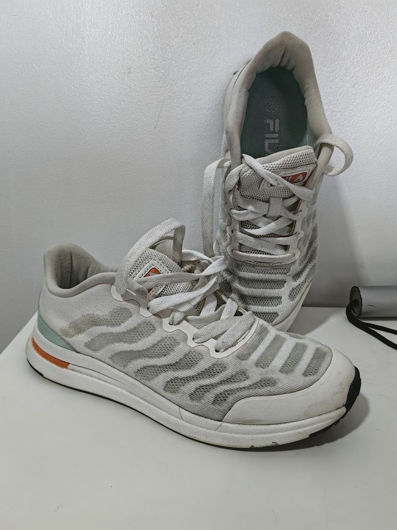 Fila Running Shoes (Category: Sneakers) located in Pasay City. Submitted by meimeitoot (Listing ID 1431577564, Image 1). Description: - White Fila running shoes - Breathable mesh upper - Cushioned sole for comfort - Secure lace-up closure - Convenient heel pull tab - Fila logo detail - Stylish sole with orange and teal accents.