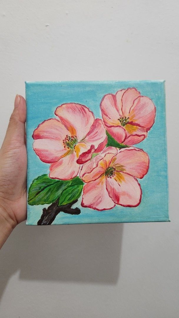 Floral Painting on Canvas (Category: Art & Prints) located in Manila. Submitted by joycreates (Listing ID 1431784498, Image 2). Description: - Original floral painting - Features three pink flowers and green leaves - Set against a light blue background - Painted on a square canvas - Perfect for home or office - A unique art piece -15×15cm -frame is not included.