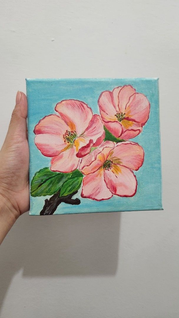 Floral Painting on Canvas (Category: Art & Prints) located in Manila. Submitted by joycreates (Listing ID 1431784498, Image 3). Description: - Original floral painting - Features three pink flowers and green leaves - Set against a light blue background - Painted on a square canvas - Perfect for home or office - A unique art piece -15×15cm -frame is not included.