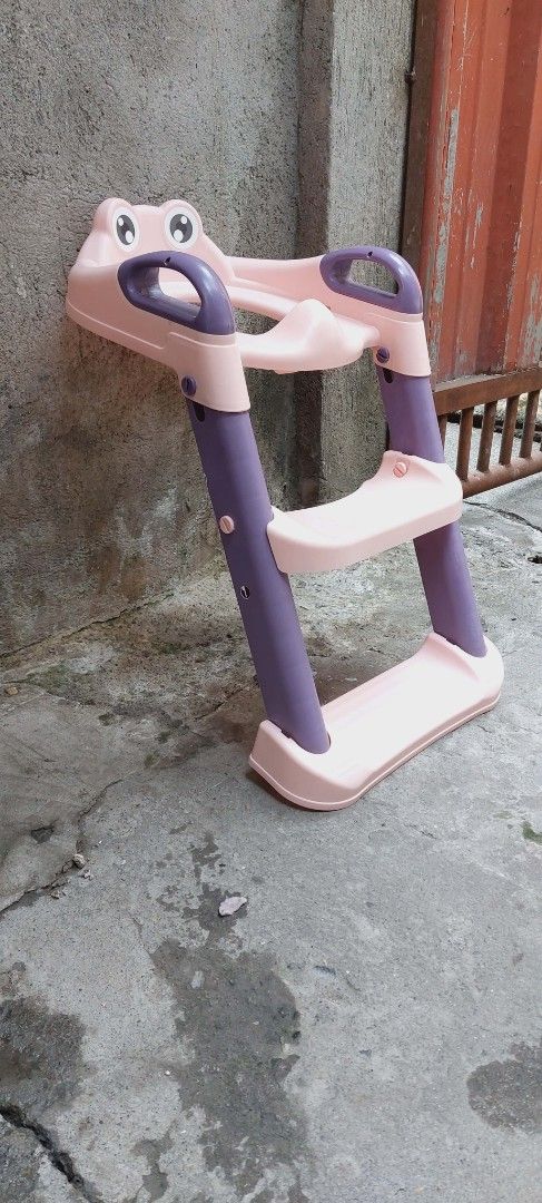 Potty Training Frog-Shaped Step Stool (Category: Chairs) located in Quezon City. Submitted by mkesimsa_six67 (Listing ID 1431592576, Image 3). Description: - Adorable frog design - Two-step stool - Features safety handles - Pink with purple accents - Made of durable plastic - Ideal for young children - Helps kids reach elevated surfaces like sinks.