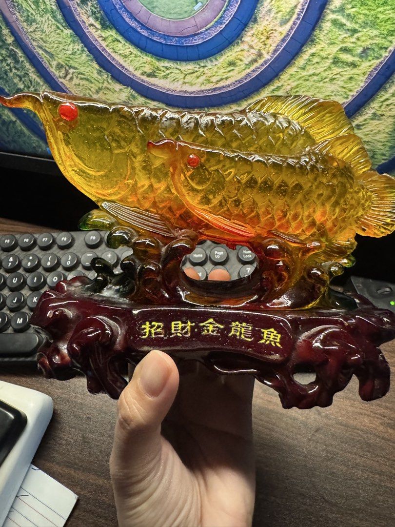 Golden Arowana Fish Ornament (Category: Other Home Decor) located in Las Pinas. Submitted by nekomeow22 (Listing ID 1431576053, Image 1). Description: - Golden Arowana fish design - Mounted on a dark red wooden base - Features Chinese characters - Red-eyed with detailed scales - Intricate carvings on the base - Ideal for desk or shelf display.