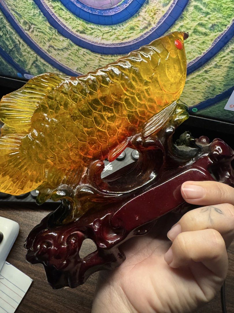 Golden Arowana Fish Ornament (Category: Other Home Decor) located in Las Pinas. Submitted by nekomeow22 (Listing ID 1431576053, Image 2). Description: - Golden Arowana fish design - Mounted on a dark red wooden base - Features Chinese characters - Red-eyed with detailed scales - Intricate carvings on the base - Ideal for desk or shelf display.