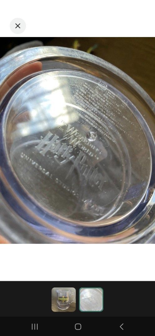 Harry Potter Universal Studios Butterbeer Mug (Category: Coffee & Tea Tableware) located in Valenzuela. Submitted by winssian (Listing ID 1431794152, Image 2). Description: - Clear plastic mug - Features Butterbeer label - Includes handle and base - Marked with Universal Studios logo Displayed only.