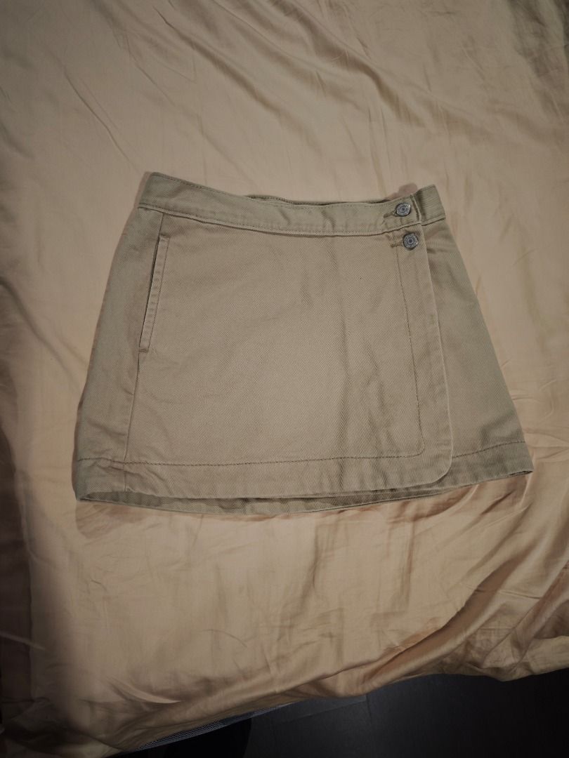 Levi's Skirt (Category: Skirts) located in Quezon City. Submitted by declutteringmami (Listing ID 1431665637, Image 1). Description: - Levi's skirt - Light beige color - Wrap-style front with two buttons - Levi's logo tag at the back - Size: W25 - Made of sturdy fabric - Classic and versatile design - Ideal for casual wear -Never used -Missing one button.