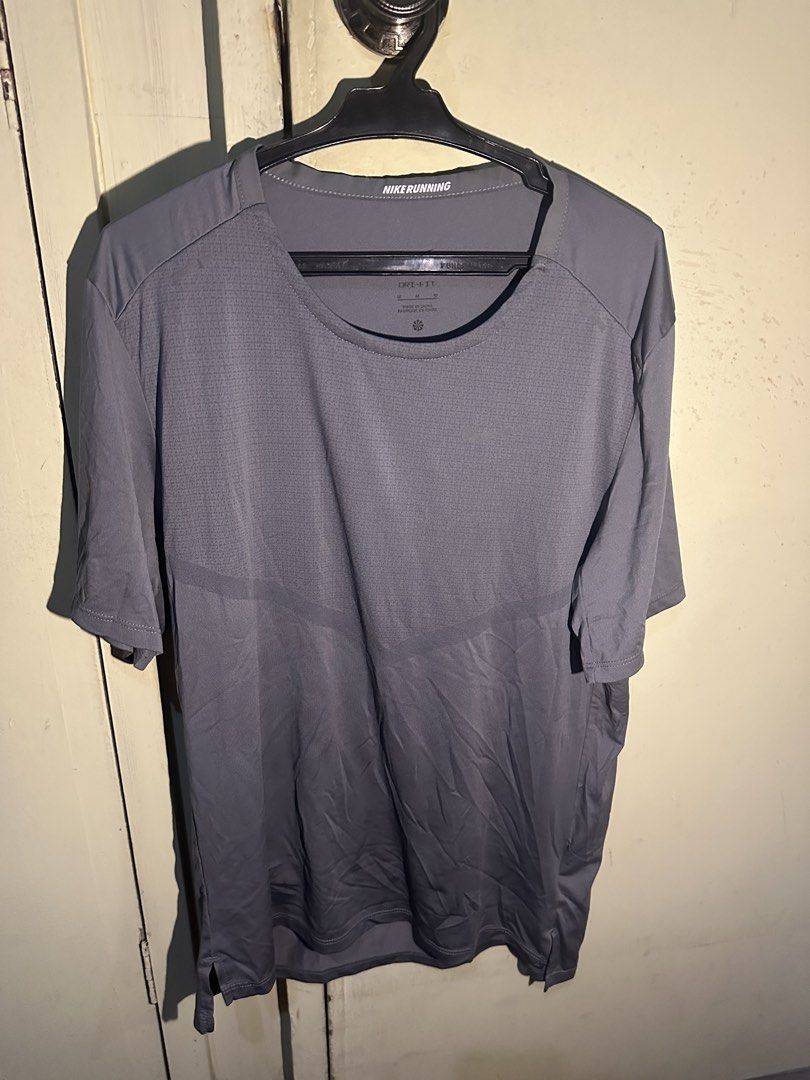 Nike Running Dri-FIT ADV Gray T-shirt - Medium (Category: Activewear) located in Manila. Submitted by nuggs267 (Listing ID 1431767486, Image 1). Description: Nike Running Dri-FIT ADV gray t-shirt. Features a crew neck and short sleeves. Made of 100% polyester. Size M. The shirt has the Nike logo on the front and the "Nike Running" label on the collar. Made in China. Slightly used Rfs: too small for me.