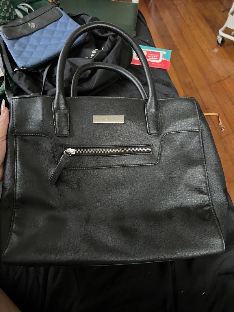 Nine West Black Handbag (Category: Luxury Bags & Wallets) located in Makati City. Submitted by tilli28 (Listing ID 1431578842, Image 1). Description: - Nine West black handbag - Top handles - Front zipper pocket - Silver-tone logo plate - Interior shows wear and tear - Damage on handles and lining - Functional for everyday use.