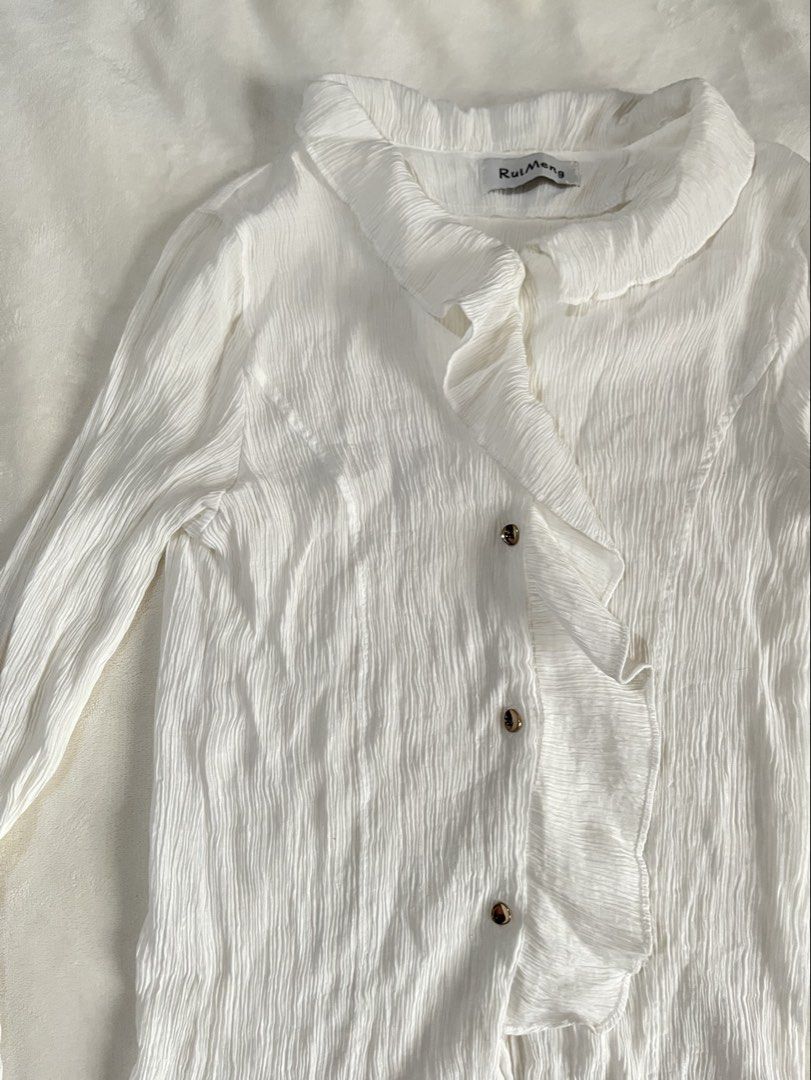 Office / Corporate White Ruffle Blouse Longsleeves (Category: Blouses) located in Mandaluyong City. Submitted by mandmclosey_ (Listing ID 1431659020, Image 3). Description: - RuiMeng white blouse - Ruffled front and collar - Long sleeves with flared cuffs - Button closures - Textured fabric - Measurements: - Length: 22 inches - Width: 13 inches - Sleeves: 22 inches Loc: Mandaluyong City Mode of payment: Gcash only!! Mode of delivery: lalamove/ang